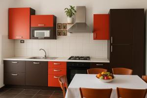 a kitchen with red cabinets and a table with a bowl of fruit at Trevisan in Cerea