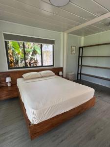 a bedroom with a large bed with a large window at Salty studio apt Santa Teresa center in Santa Teresa Beach