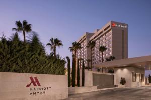 a hotel with palm trees in front of a building at Amman Marriott Hotel in Amman