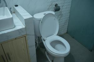 a small bathroom with a toilet and a sink at Villa edelweis in Ngingas