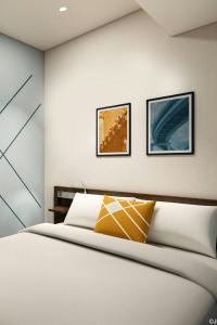 東京にあるフォーポイント フレックス by シェラトン 東京渋谷ウエストのベッドと壁に2枚の絵が飾られた寝室