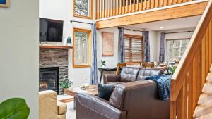 Una sala de estar con un sofá y una chimenea. en Rustic-Chic Escape w Hot Tub Fireplace Nature Views Pine Woods Loft, en Lehigh