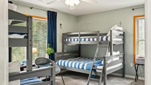 Un dormitorio con literas y una ventana. en Rustic-Chic Escape w Hot Tub Fireplace Nature Views Pine Woods Loft, en Lehigh