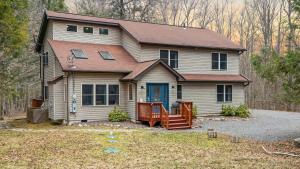 una casa con una puerta azul y un patio en Rustic-Chic Escape w Hot Tub Fireplace Nature Views Pine Woods Loft, en Lehigh