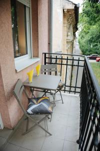 a table and chairs on a balcony with a window at Todi & Dana in Sombor