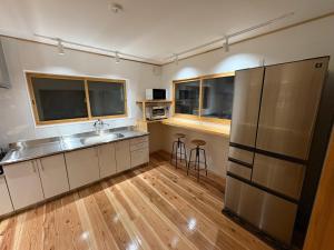 a kitchen with a sink and a refrigerator at Kitakaze House in Myoko +11 photos