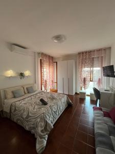 a bedroom with a large bed and a couch at B&B L'Orchidea in Pisa