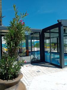 a building with glass doors and a pool at Gyps Vikendica with Swimming Pool and Sauna 2 in Tuzla