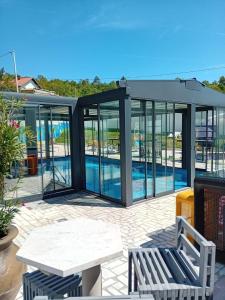 a glass house with a pool in it at Gyps Vikendica with Swimming Pool and Sauna 2 in Tuzla +16 photos