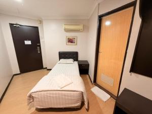 a small room with a bed and a door at Swing & Pillows - Dataran Nilai in Nilai