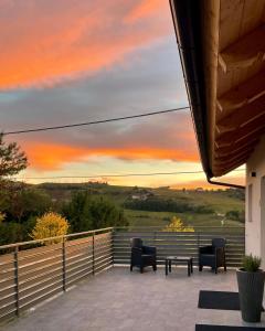 a patio with chairs and a table and a sunset at Cascina Ricardin in Coazzolo