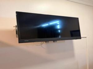 a flat screen tv hanging on a wall at Swing & Pillows - Dataran Nilai in Nilai +5 photos