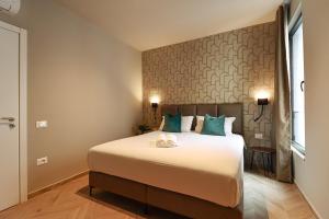 a bedroom with a large white bed with blue pillows at Azure Escape luxury apartments Sarande in Sarandë