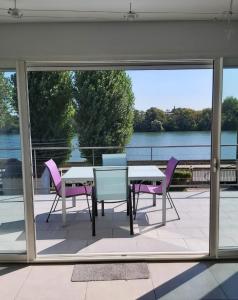 a patio with a table and chairs and a view of the water at Apartment L'Aquarius in Villeneuve-le-Roi