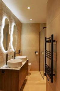 two sinks in a bathroom with two mirrors at Azure Escape luxury apartments Sarande in Sarandë +26 photos