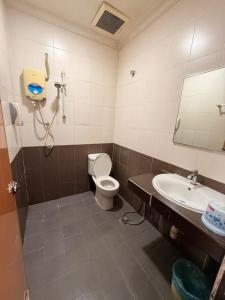 a bathroom with a toilet and a sink and a mirror at Swing & Pillows - Dataran Nilai in Nilai