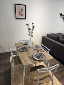 een eettafel met een vaas met bloemen erop bij Le Fécamp central, centre ville à 1km de la plage in Fécamp
