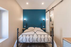 - une chambre dotée d'un lit avec un mur bleu dans l'établissement Bâtiment Les Iris, à Bourg-Saint-Andéol