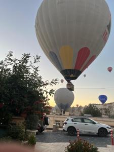 a car parked in a parking lot with hot air balloons at Virtus Cappadocia Hotel Göreme in Goreme