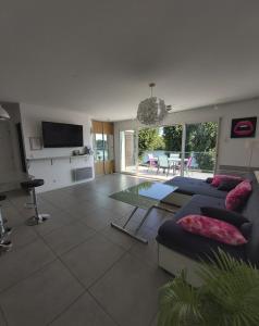 a living room with a couch and a tv at Apartment L'Aquarius in Villeneuve-le-Roi +18 photos
