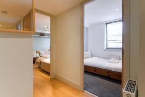 a bedroom with two beds and a mirror at Modern Flat in the Middle of Old Town in Edinburgh