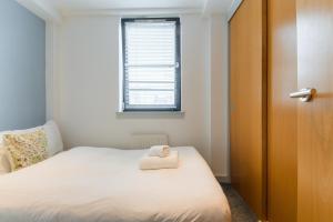 a bedroom with a bed with a towel on it at Modern Flat in the Middle of Old Town in Edinburgh