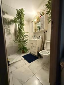 bagno con lavandino e servizi igienici con pianta di Green Apartment a Bucarest