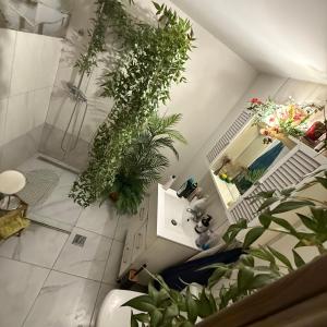 un bagno con piante, doccia e lavandino di Green Apartment a Bucarest