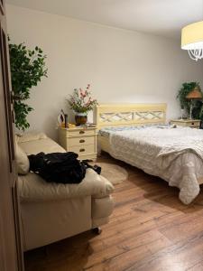 una camera da letto con due letti e un divano di Green Apartment a Bucarest Altre 13 foto