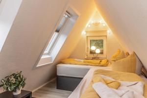 a attic bedroom with two beds and a window at Ferienwohnung KIEK RUT - am Deich in Wittmund