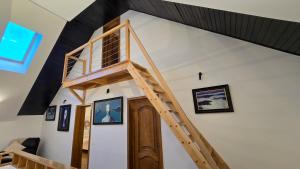 a room with a loft bed with a wooden staircase at Evie's Tree House in Dragomirna