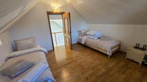 a attic room with two beds and a mirror at Evie's Tree House in Dragomirna