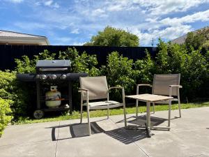 two chairs and a table and a grill at Travellers' dream steps from shops and close to Airport in Christchurch