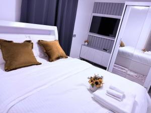 a bedroom with a large white bed with a mirror at Beautiful and Spacious 1 Bedroom Apartment in Erith