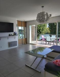 a living room with a tv and a table with chairs at Apartment L'Aquarius in Villeneuve-le-Roi