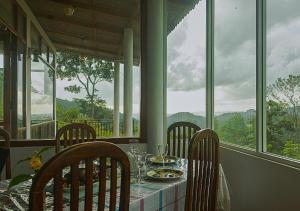 a table with chairs and plates of food on it at Knight's Dale Knuckles Holiday Bungalow in Kandy +3 photos