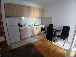 SJJSarajevo Holiday Apartment 4的厨房配有白色冰箱和黑色椅子