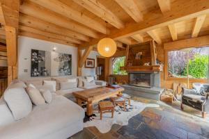 una sala de estar con un sofá y una mesa en Alpine Luxury Chalet Pool & Jacuzzi, en Cordon