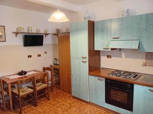 a kitchen with blue cabinets and a small table at Le Scalette Casa Vacanze in Acquapendente