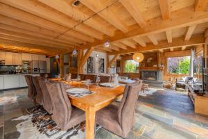 a kitchen and dining room with a wooden table and chairs at Alpine Luxury Chalet Pool & Jacuzzi in Cordon