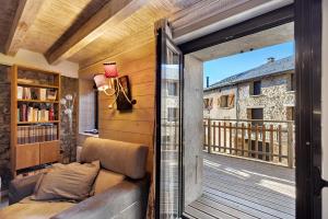 a living room with a couch and a balcony at Maison de village Ramballade in Les Angles