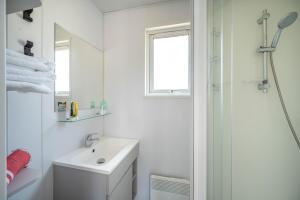 ein weißes Badezimmer mit Waschbecken und Dusche in der Unterkunft Camping Clicochic Petit Nice in Pyla-sur-Mer + 26 Fotos