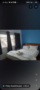 een slaapkamer met een bed met witte lakens en een raam bij Italay in Krabi town