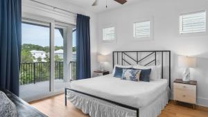 圣罗莎海滩Walk to Beach Pool Hot Tub Game Room 30A Ohana Grande by AvantStay的一间带床和阳台的白色卧室 更多62张照片