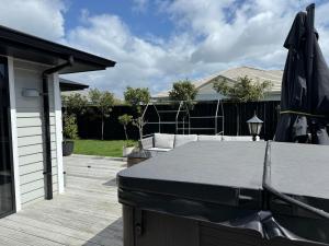 a patio with a table and an umbrella at Beach days and cozy stays - sleeps seven in Tauranga