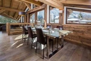 a dining room with a glass table and chairs at Chalet Les Praz - Chamonix All Year in Chamonix