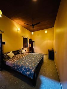 a bedroom with a bed and a yellow wall at Marwar Mosaic Heritage Haveli in Jodhpur