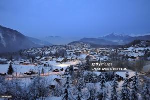 a city covered in snow with mountains in the background at La Mutelline - Les Carroz in Arâches-la-Frasse