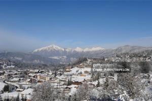 a city covered in snow with mountains in the background at La Mutelline - Les Carroz in Arâches-la-Frasse +2 photos
