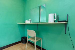 Una silla colocada sobre un estante con un espejo. en X GO INN The Giant Swing เสาชิงช้า, en Bangkok